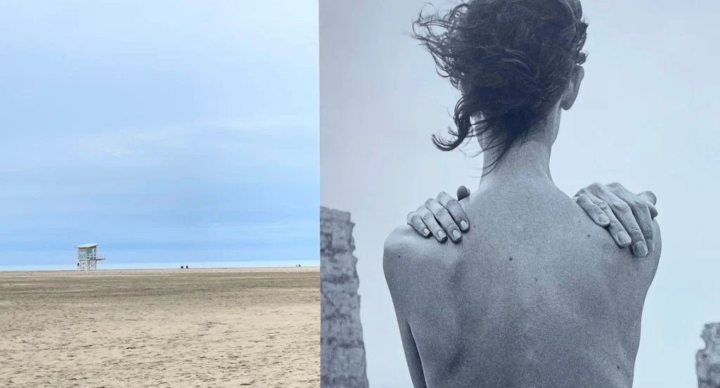 Installation photographique du festival Planches Contact sur la plage de Deauville — grand tirage noir et blanc représentant une femme vue de dos face aux rochers