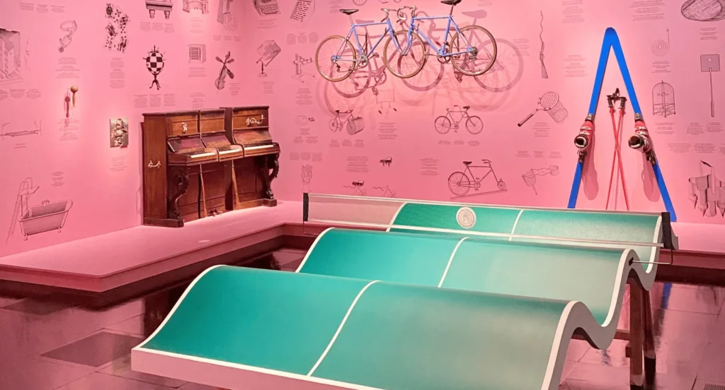 Prototypes et objets expérimentaux dont des vélos atypiques exposés dans un espace coloré, illustrant les tentatives et détours du design industriel.