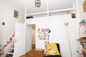 Espace nuit en mezzanine avec couchage et rangements sous plafond, optimisation des volumes, chambre atypique.