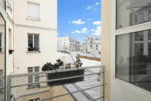 Vue dégagée sur les toits parisiens et immeubles du quartier Sentier depuis les fenêtres de l’appartement.