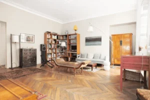 Salon principal avec parquet massif, placards anciens, espace réception et coin détente, appartement de caractère place du Caire.