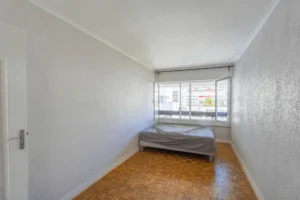 Chambre d’un appartement 2 pièces à Paris 12 Reuilly Diderot avec parquet mosaïque, grande fenêtre offrant une vue dégagée et belle luminosité naturelle.