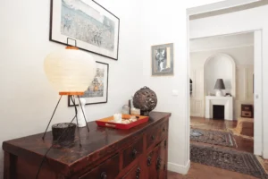 Détail mobilier ancien et perspective vers le séjour, parquet d’origine et ambiance chaleureuse, appartement haussmannien Paris 2.