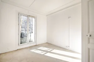 Chambre lumineuse avec grande fenêtre et vue arborée, parquet et murs blancs, appartement en duplex à vendre Paris 12 Porte de Vincennes Avenue Saint-Mandé.