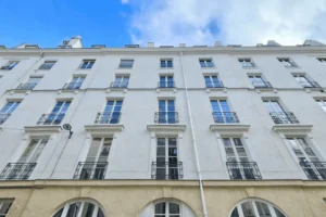 Façade d’un immeuble ancien rue d’Aboukir, à proximité immédiate de la place du Caire, Paris 2ᵉ arrondissement, avec fenêtres à la française et garde-corps en ferronnerie.