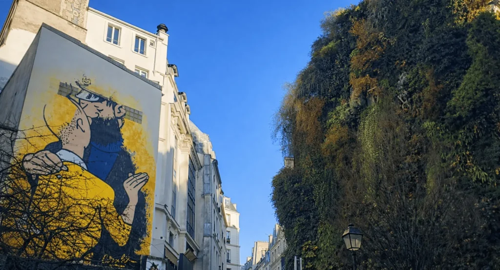 Rue d’Aboukir dans le quartier Sentier Montorgueil à Paris 2, fresque murale contemporaine et façade végétalisée, atmosphère créative et résidentielle au cœur du centre historique – Quality Street Immobilier