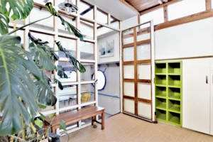 Verrière intérieure et espace de circulation d’une péniche aménagée en style loft avec rangements intégrés à Levallois-Perret quai Charles Pasqua.