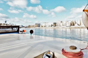 Grand pont extérieur d’une péniche d’habitation amarrée quai Charles Pasqua à Levallois-Perret avec vue dégagée sur la Seine et les immeubles du quai opposé.