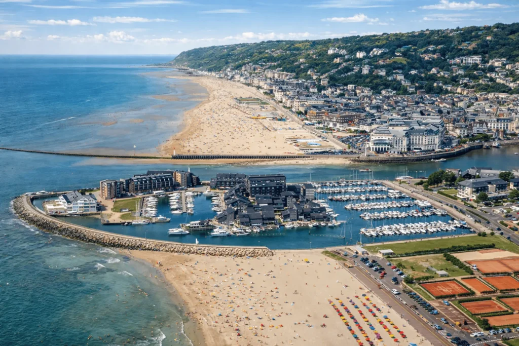 Vue aérienne de la Marina de Deauville avec le port de plaisance, la plage de Deauville et la ville de Trouville-sur-Mer sur la Côte Fleurie.
