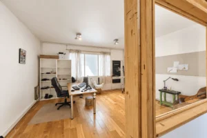 Espace bureau avec parquet dans un loft mixte à Montreuil.