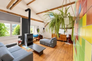 Séjour avec poêle, parquet ancien et poutres apparentes à Montreuil.