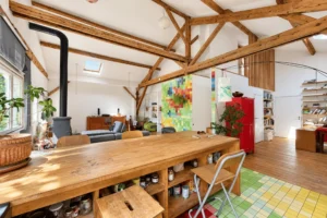 Grande pièce de vie avec charpente en bois apparente dans un loft à Montreuil.